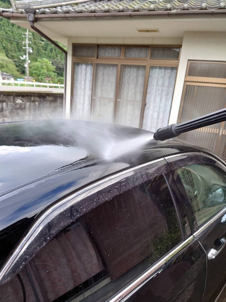 高圧洗浄機の水を車に当てている写真